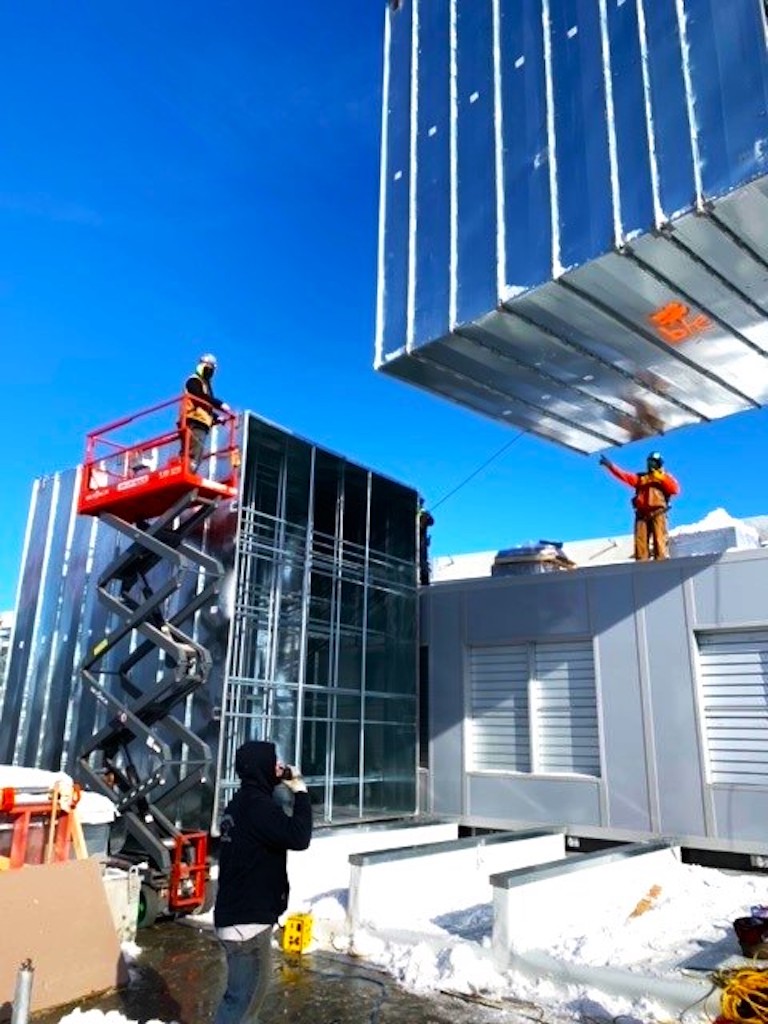 workers loading large ductwork into place 